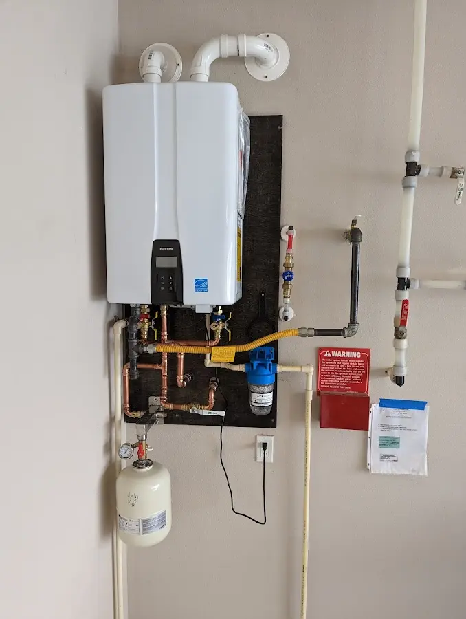 Professional plumber installing copper piping in a Layton home